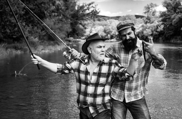 Foto visser mannen vrienden en trofee forel vader en zoon vissen generaties mannen vissen in de rivier
