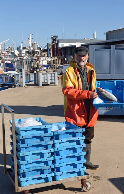 Visser met een viskist in een vissersboot