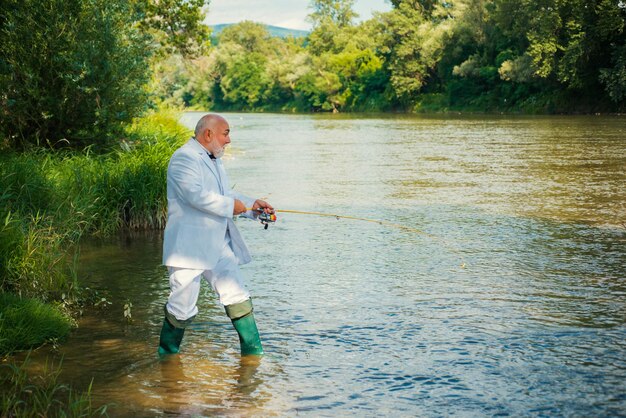 Visser senior rijke zakenman in pak ving een vis man vissen op rivier