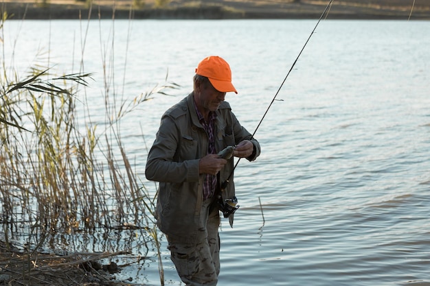 Visser staat aan de rivier en probeert een vis te vangen Sportrecreatie levensstijl