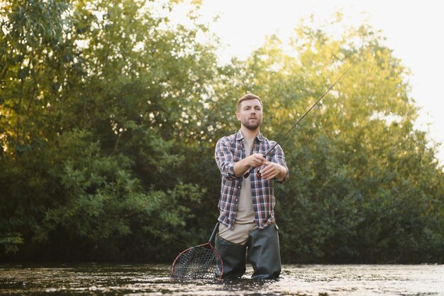 Visser vangt een forel op de rivier in de zomer