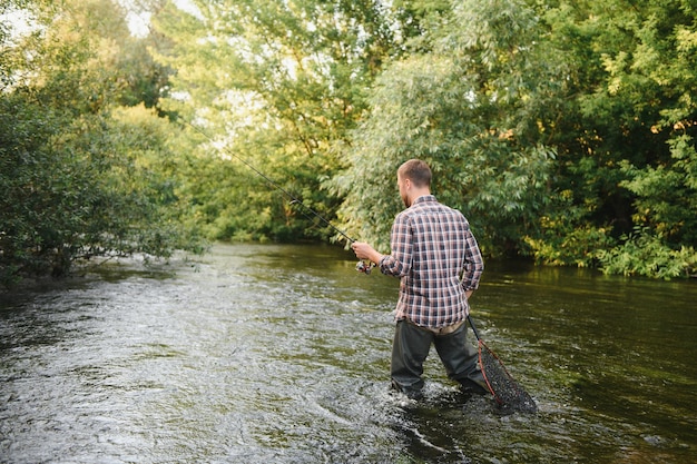 Visser vangt een forel op de rivier in de zomer