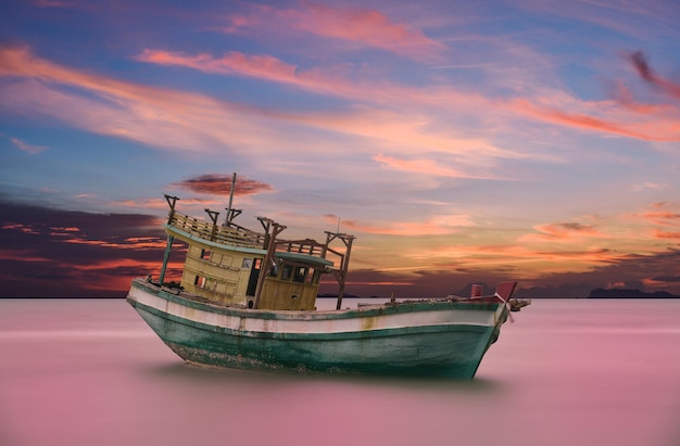 Visserijboot op zee tegen de hemel tijdens zonsondergang