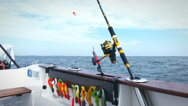 Foto visserijstok op een boot op zee tegen bewolkte lucht