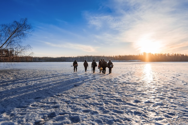 Foto vissers gaan op het ijs in de winter op een zonnige dag