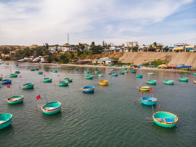 Vissers mand boten op het Vietnamese vissersdorp, kleurrijke traditionele vissersboot afgemeerd Mui Ne, Vietnam. Bovenaanzicht. Luchtfoto