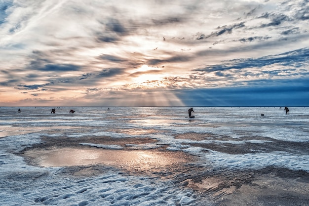 Vissers vissen bij zonsopgang op ijzige winterochtend