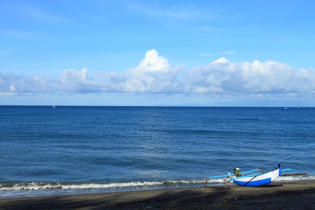 Vissersboot op het strand met blauwe zee en bewolkte hemel op de achtergrond Lombok eiland Indonesië