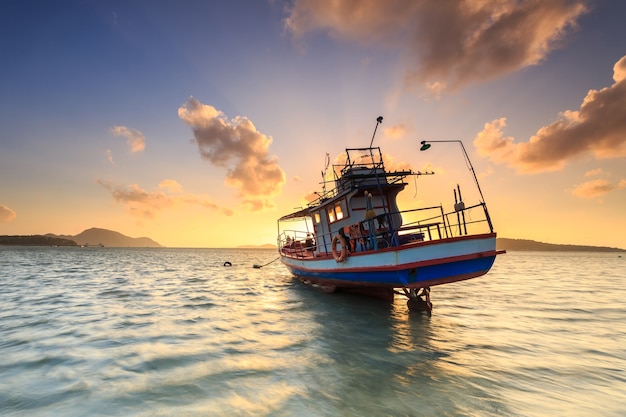 Vissersboottribune bij zonsopgangstrand in Phuket, Thailand