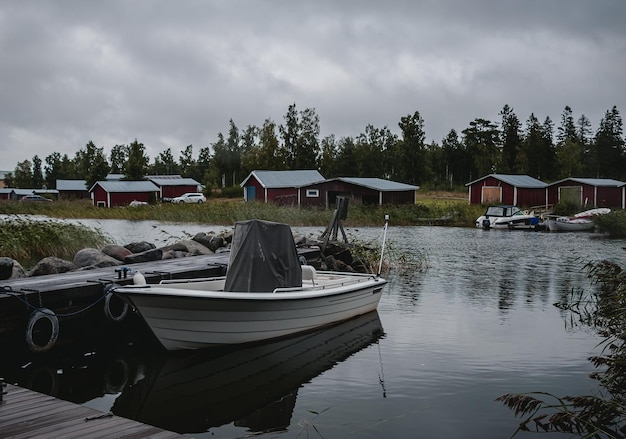 vissersboten en rode houten hutten aan de oever van een meer in Finland