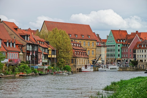 Foto vissershuizen over regnitz-rivier in klein venetië in bamberg in opper-franken, beieren, duitsland. mensen op de achtergrond