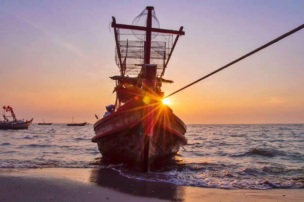 Vissersschip op de kust met tijdens zonsondergang