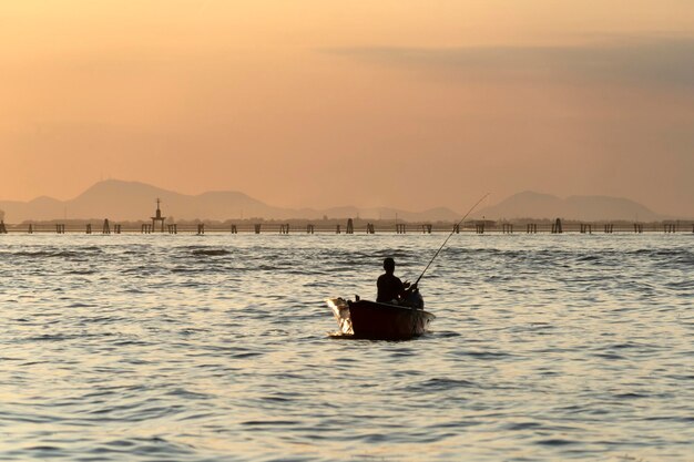 Visserssilhouet bij zonsondergang in de haven van chioggia in de lagune van Venetië vanaf een boot