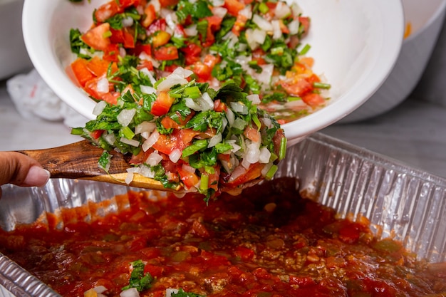 사진 비스타 프론탈 시르비엔도 엔살라다 picada sobre un bowl de aluminio