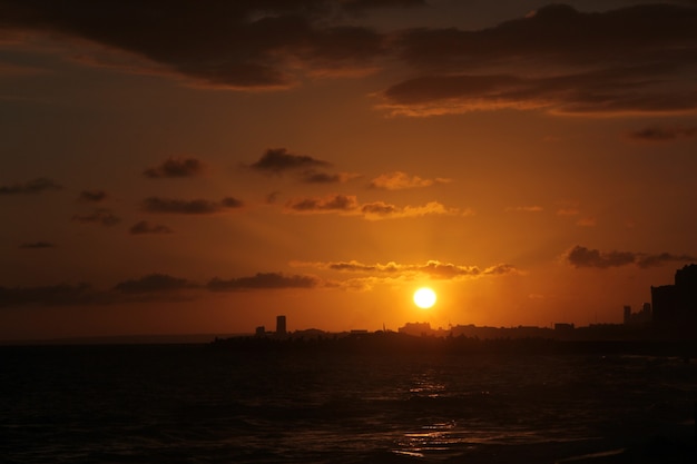 Vista panoramica de la puesta de sol luz naranja en silueta de la cuidad