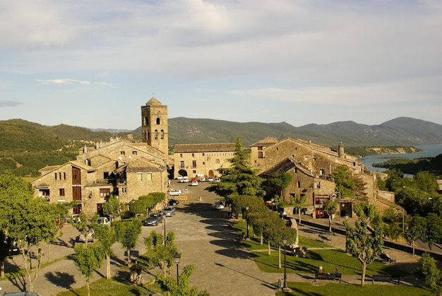 vistas del pueblo 중세 de Aínsa. Plaza, torre de iglesia y árboles en el pirineo.