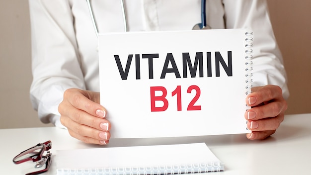 VITAMIN B12 card in hands of medical Doctor. Doctor's hands a sheet of paper with text VITAMIN B12, medical concept.