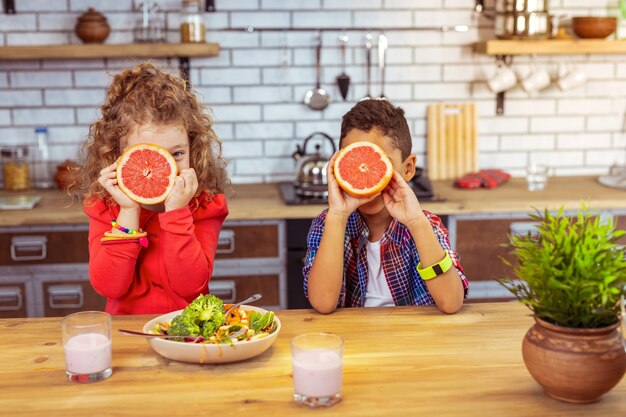 Photo vitamin c. amazing blonde girl looking straight at camera and sitting close to her international friend