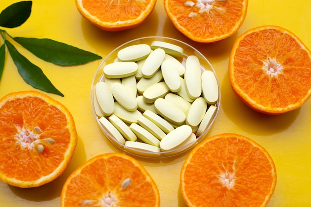 Vitamin C pills with fresh orange citrus fruit