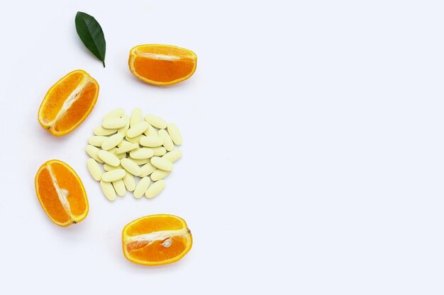 사진 색 바탕에 오렌지색 과일이 있는 비타민 c 알약