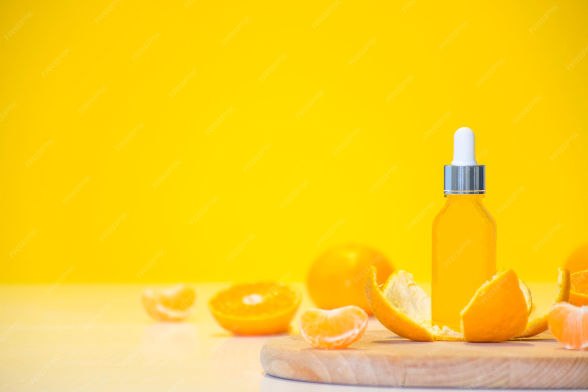 Premium Photo | Vitamin c serum cosmetic bottle in tangerine peel with orange pieces on yellow background with copy space.