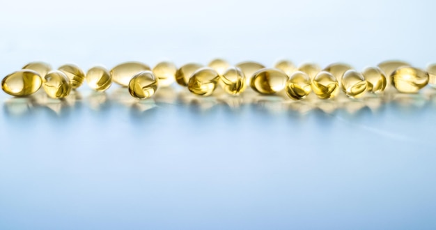 ビタミン D と黄金のオメガ 3 錠剤健康的な食事栄養魚油食品サプリメント錠剤カプセル ヘルスケアと薬薬局の背景として