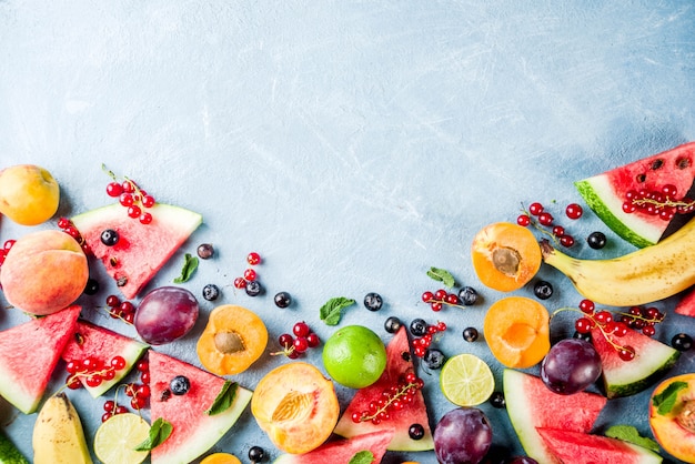 Concetto di cibo vitaminico, vari frutti e bacche anguria pesca menta prugne albicocche ribes mirtillo