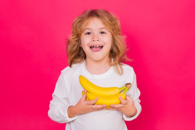 Vitamin and healthy fruits for kids Kid hold dragon fruit in studio Studio portrait of cute child with dragon fruit isolated on yellow background copy space