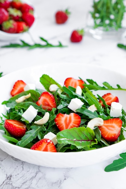 Vitamin salad of strawberry with spinach leaves cheese and nuts Vegan food keto and paleo diet