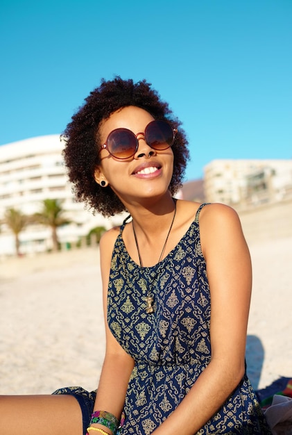 Vitamine D krijgen Bijgesneden opname van een aantrekkelijke jonge vrouw die vrijetijdskleding draagt terwijl ze alleen op het strand zit en van de zon geniet