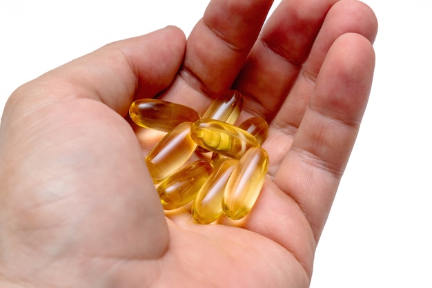 Vitamine e omega-3 visolie gele pillen in een hand vitaminen sportvoeding gezond