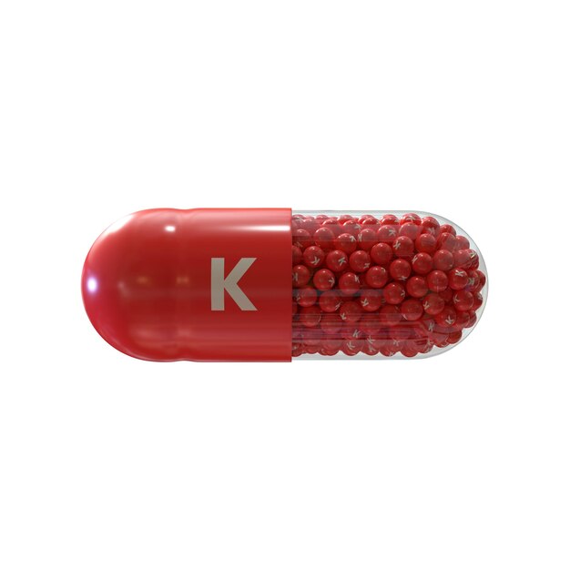 Vitamine K met rode capsule granules en witte achtergrond