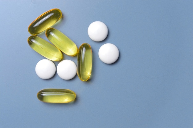 Vitaminen in capsules en tabletten op een grijze achtergrond. bovenaanzicht