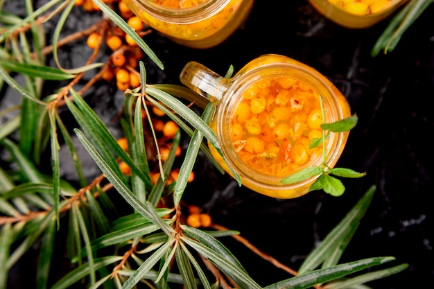 Vitaminic healthy sea buckthorn tea in small glass cups with fresh raw sea buckthorn berries, honey