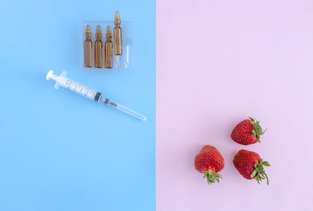 Vitamins in ampoules syringes and strawberries