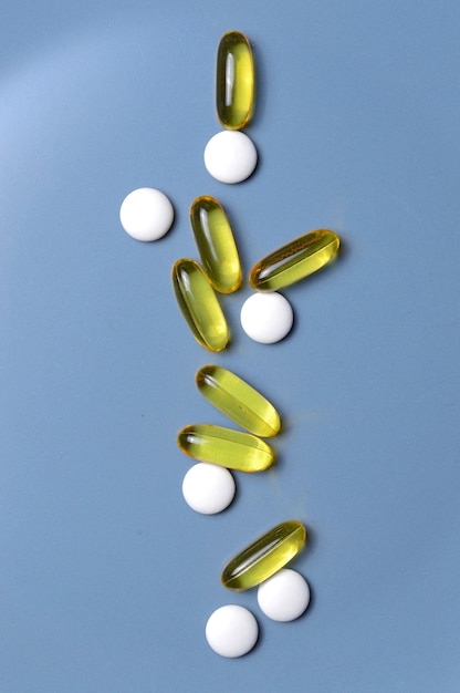 Vitamins in capsules and tablets on a gray background. top view