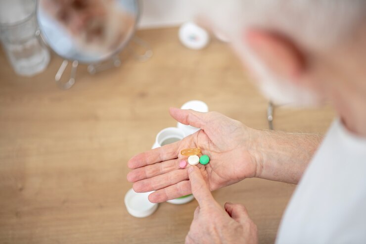 Photo vitamins. gray-haired man in white tshirt with vitamins in his hands