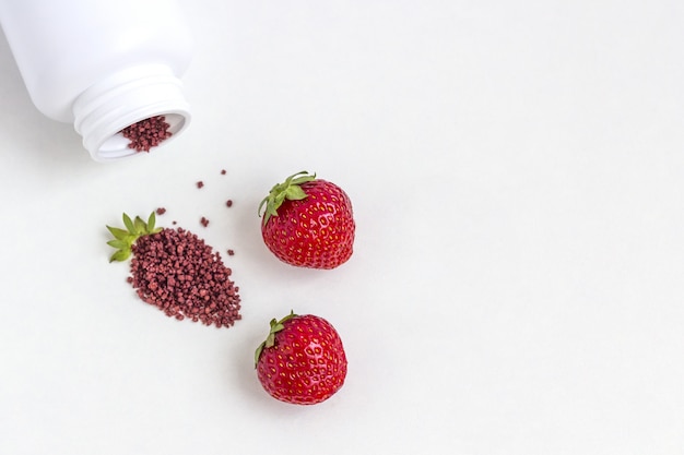 Vitamins supplements as a capsule with berries from medicine jar.