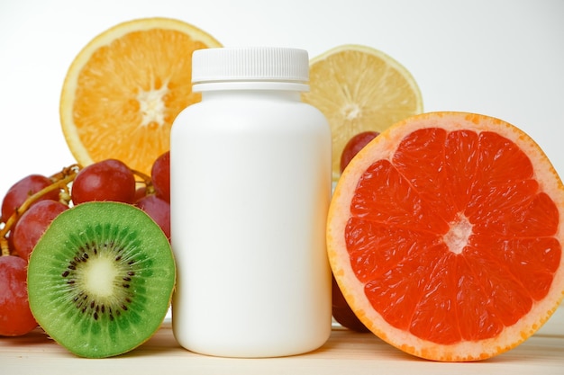 Vitamins White container for vitamins on a background of fruits Citrus lemon orange grapes Blank Medicine bottle