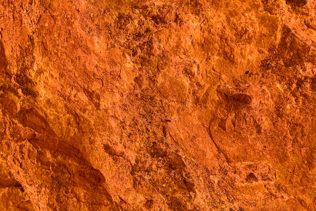 Vivid orange textured background and wallpaper, natural surface of rock formation