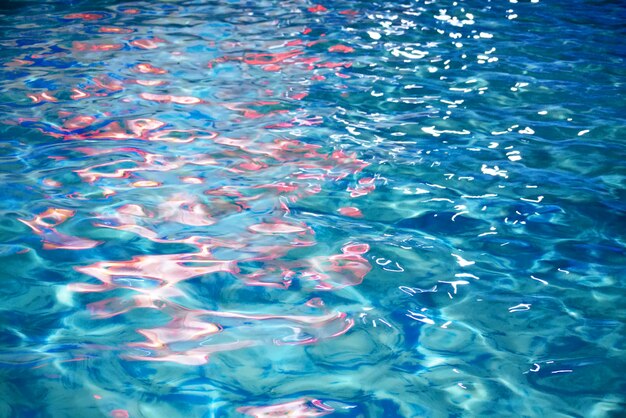 Vivid red lights reflection on wavy blue water surface