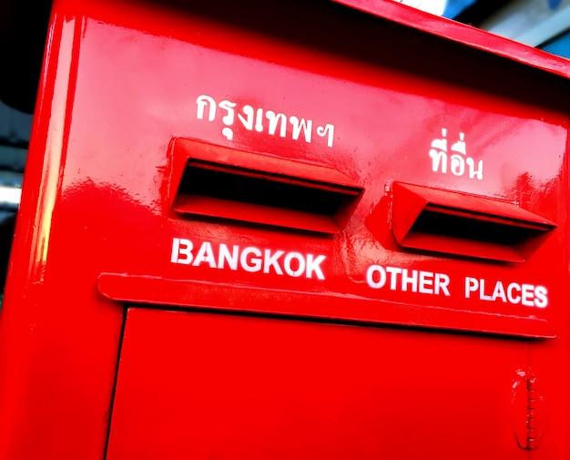 Photo vivid red postbox with destination texts in english and thai