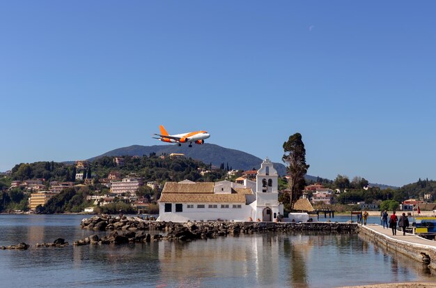 Vlacherna-klooster van Panayia en een vliegend vliegtuigGrieks eiland Corfu