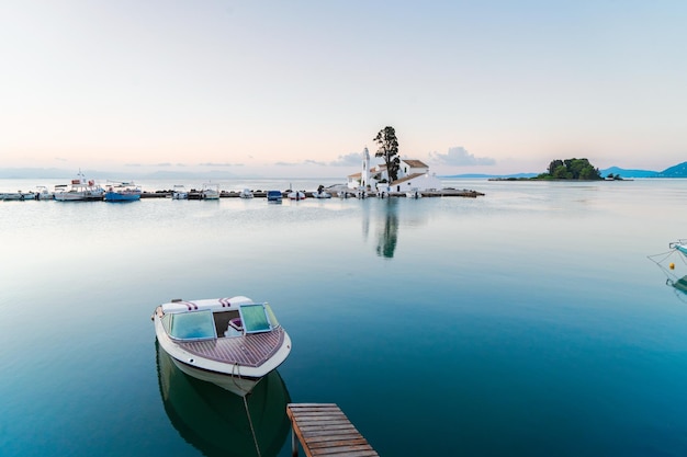 Vlacherna monastery and a boat at sunrise Kanoni Corfu island Greece