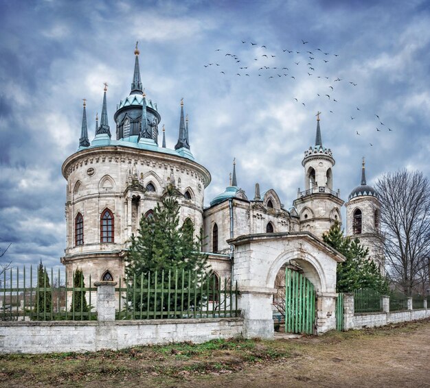 Vladimir Church in the village of Bykovo Moscow Region on an overcast cloudy day and birds in clouds