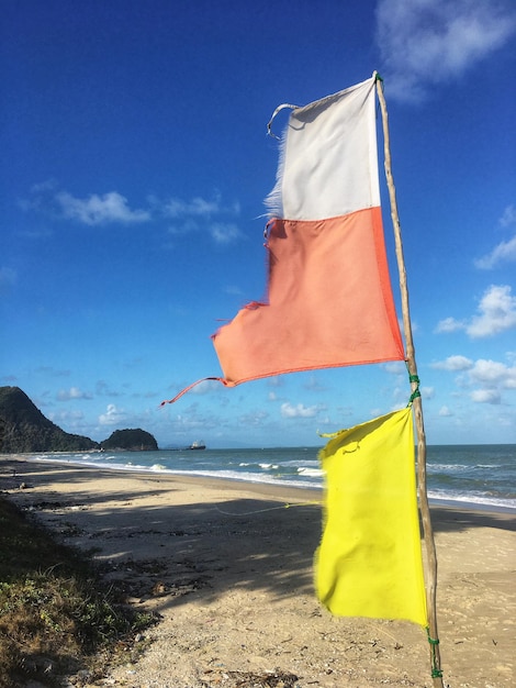 Foto vlag op het strand tegen de blauwe hemel