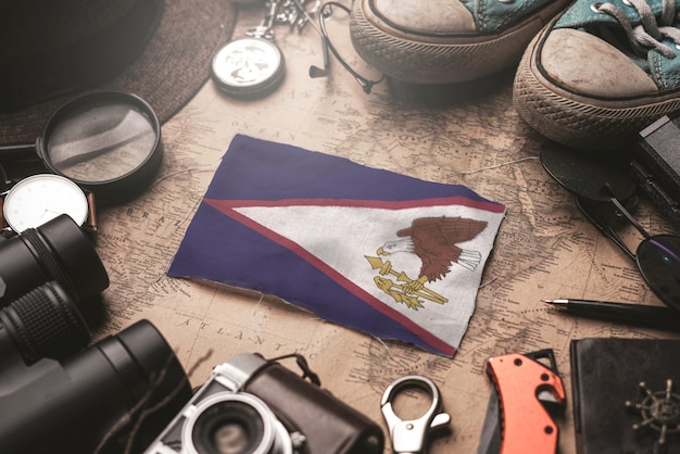 Vlag van amerikaans-samoa tussen de accessoires van de reiziger op oude vintage kaart. toeristische bestemming concept.