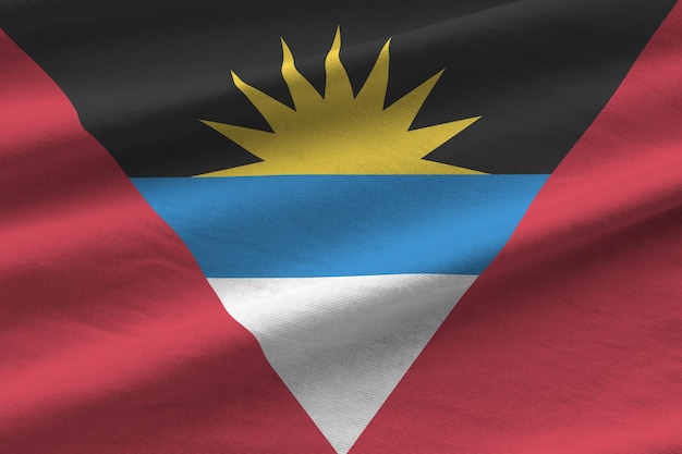 Vlag van Antigua en Barbuda met grote vouwen die dicht onder het studiolicht binnenshuis zwaaien De officiële symbolen en kleuren in banner