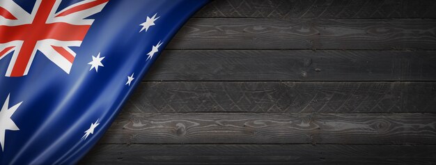 Vlag van Australië op zwarte houten muur. Horizontale panoramische banner.