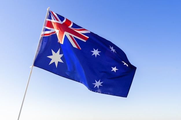 Vlag van Australië zwaaien tegen helderblauwe hemel